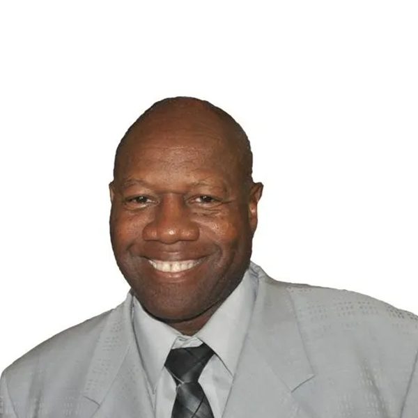 A man in a suit and tie smiling for the camera.