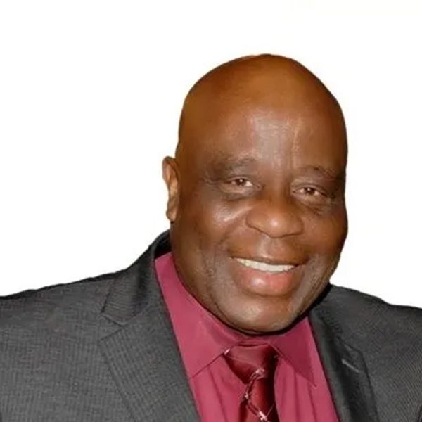 A man in a suit and tie smiling for the camera.