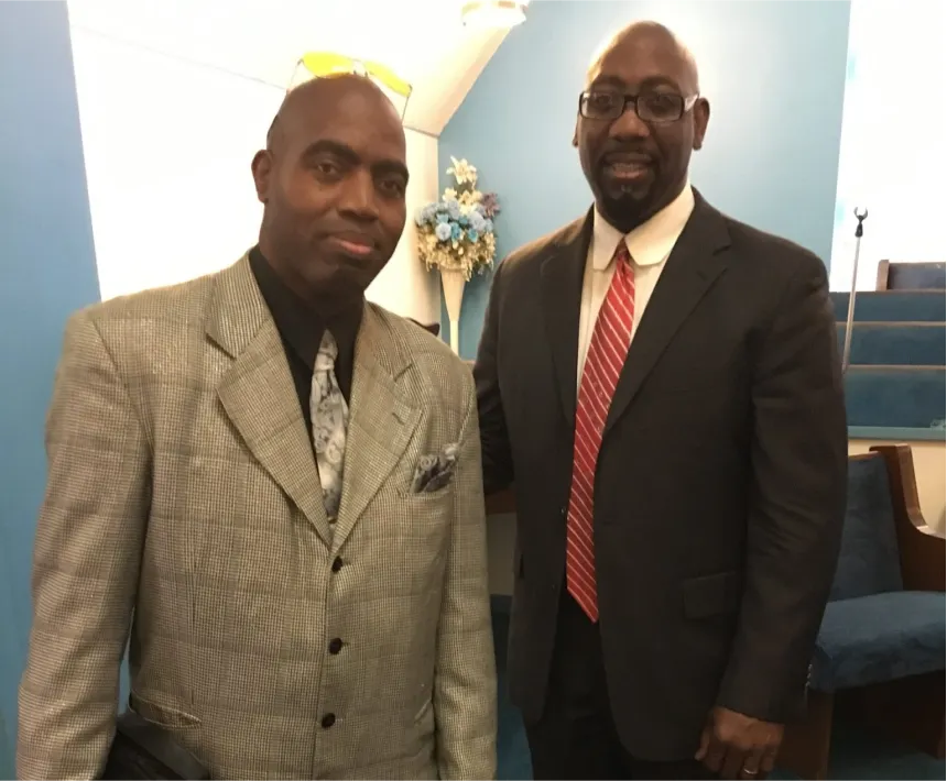 Two men in suits and ties standing next to each other.